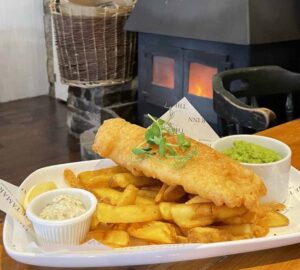 Fish and chips with roaring fire in background