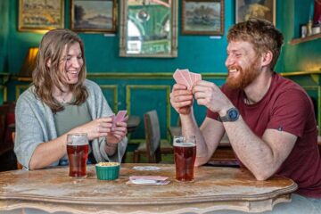 Couple playing cards with beer and peanuts