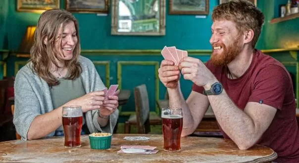 Couple playing cards with beer and peanuts