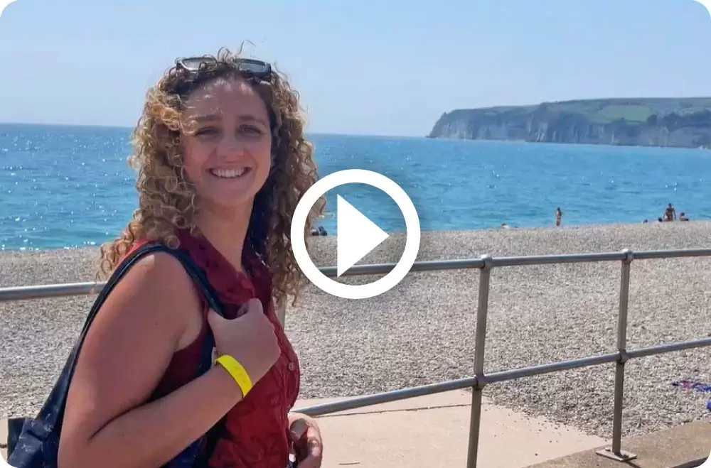 Person at Seaton beach with play button superimposed