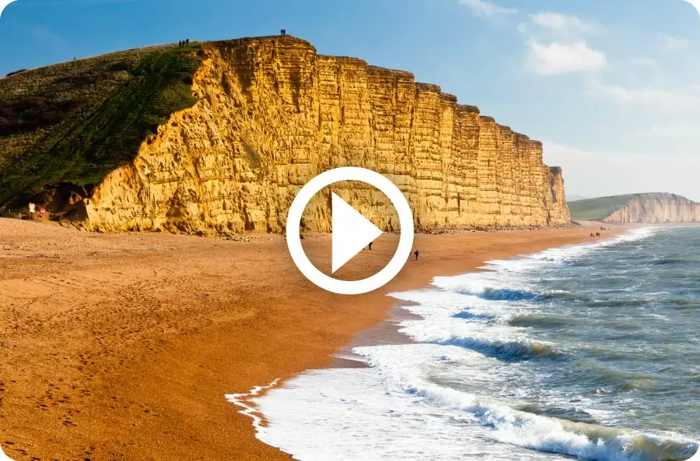 West Bay beach with play button superimposed